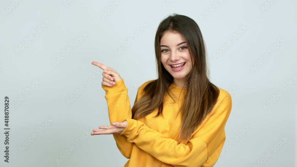 Young caucasian woman pointing finger to the side and presenting a product over isolated background Young caucasian woman pointing finger to the side and presenting a product over isolated background