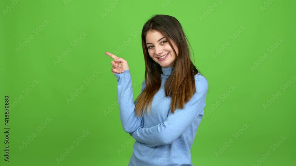 Young caucasian woman pointing finger to the side and presenting a product over isolated background. Green screen chroma key Young caucasian woman pointing finger to the side and presenting a product over isolated background. Green screen chroma key