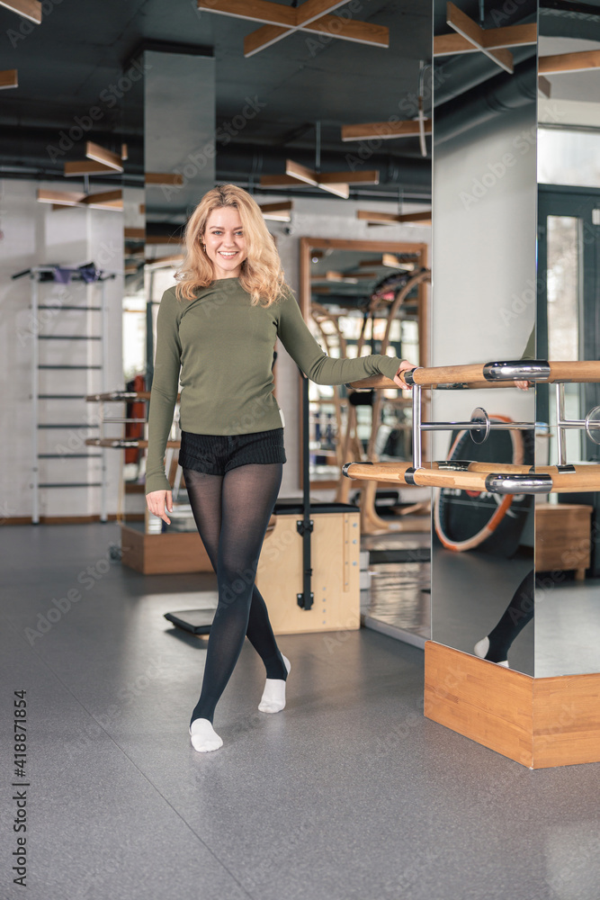 Proffesional beautiful slim caucasian woman is doing stretching exercises in modern studio Proffesional beautiful slim caucasian woman is doing stretching exercises in modern studio