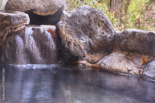 日本の温泉。岩で組んだ野天風呂のお湯の出口のイメージ