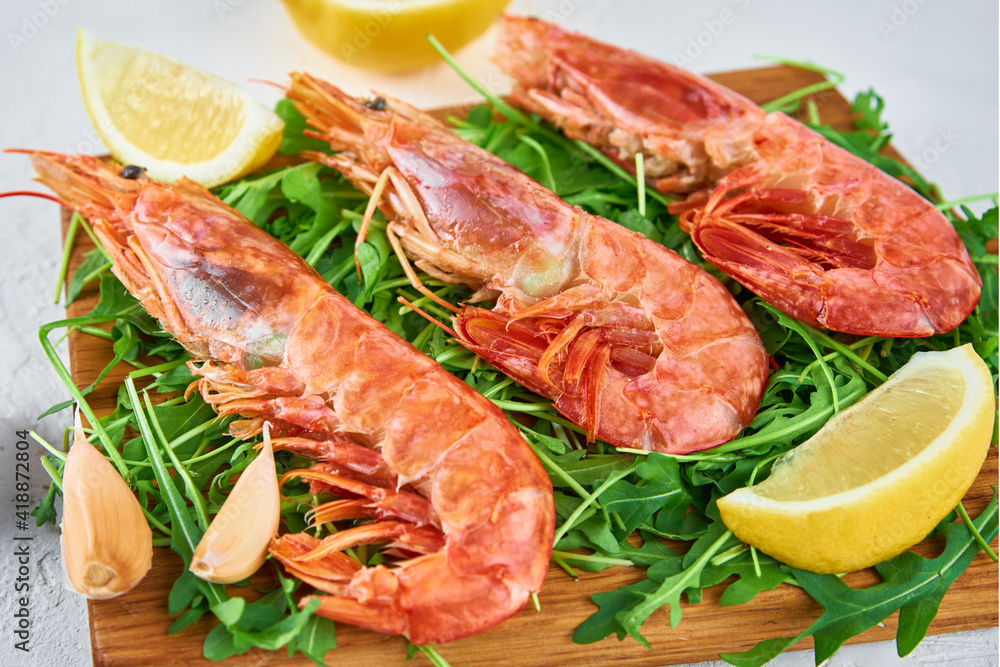 Red raw prawns, close up. Fresh shrimps with lemon and rucola. Seafood background Red raw prawns, close up. Fresh shrimps with lemon and rucola. Seafood background