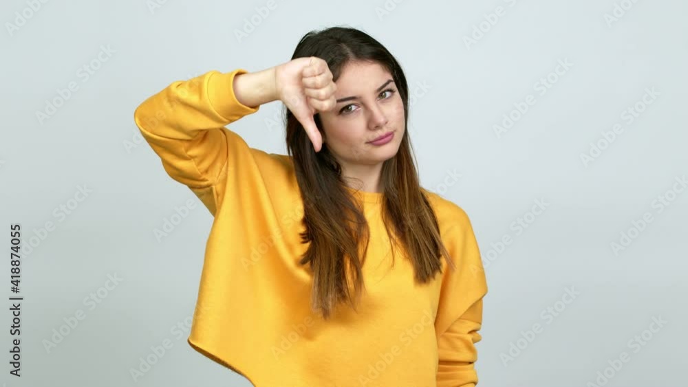 Young caucasian woman doing bad signal over isolated background Young caucasian woman doing bad signal over isolated background