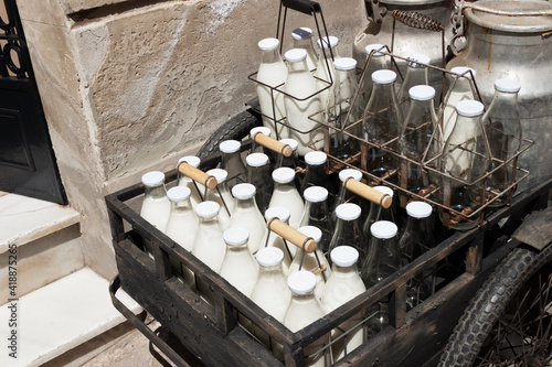Bottles and aluminum cans of milk for delivery in vintage milkman bicycle
