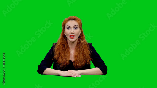 Obraz na plátně Attractive red headed female anchor presenting live news against green screen ba