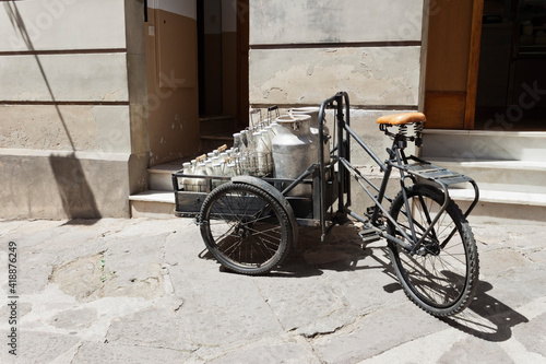 Foto Bottles and aluminum cans of milk for delivery in vintage milkman bicycle