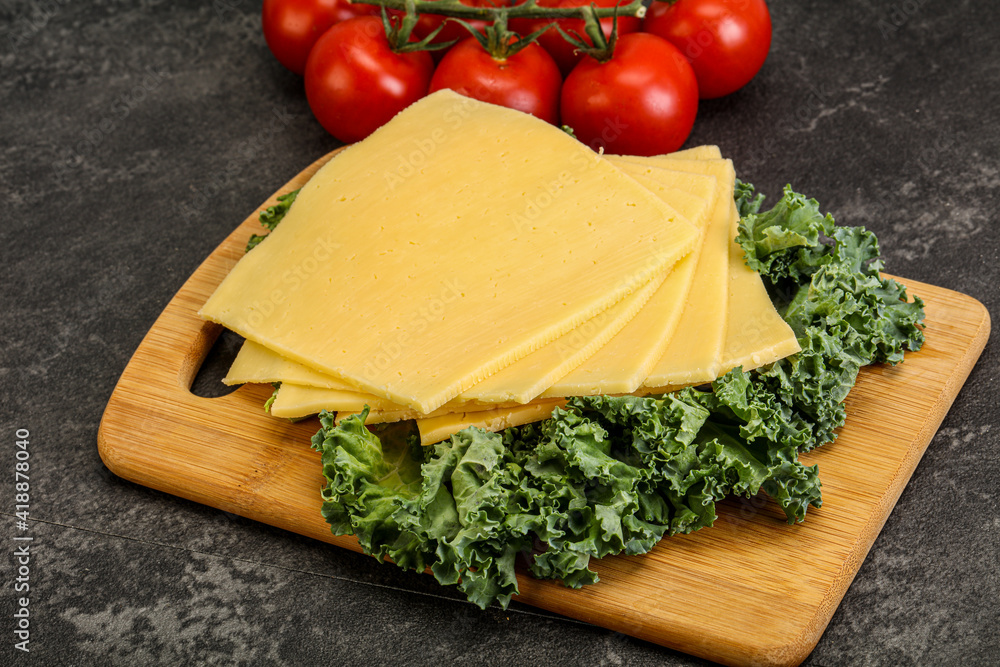 Sliced Gauda cheese over board Sliced Gauda cheese over board