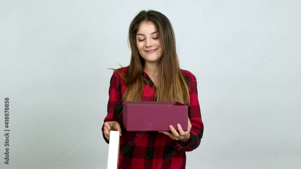 Young caucasian woman surprised and holding a gift over isolated background Young caucasian woman surprised and holding a gift over isolated background