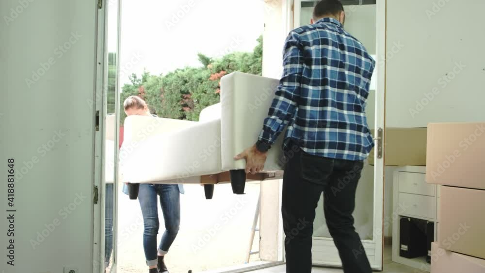 happy young couple moving carboard boxes and furnitures during move into a new home flat apartment happy young couple moving carboard boxes and furnitures during move into a new home flat apartment