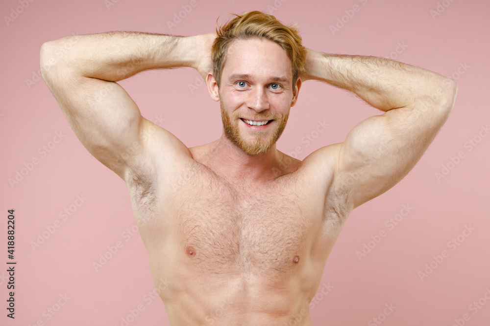 Smiling attractive bearded naked young man 20s years old perfect skin holding hands behind head isolated on pastel pink background studio portrait. Skin care healthcare cosmetic procedures concept. Smiling attractive bearded naked young man 20s years old perfect skin holding hands behind head isolated on pastel pink background studio portrait. Skin care healthcare cosmetic procedures concept.