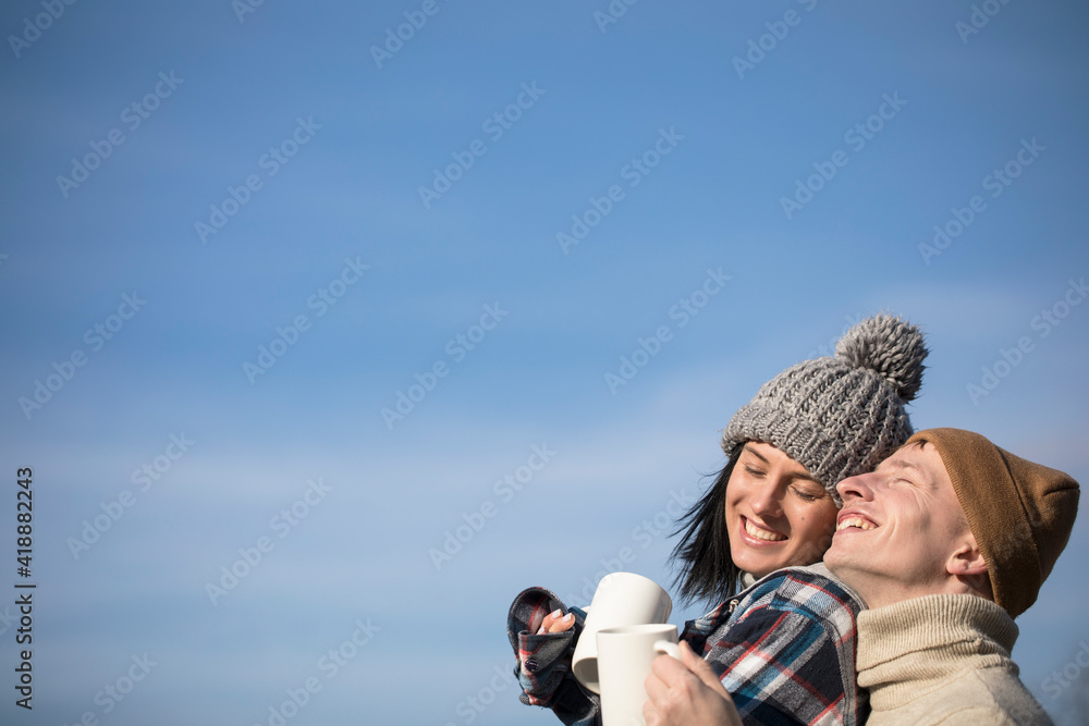 Couple drinking hot coffee. Couple in love. Smiling man and woman. Smile. Sky background. 