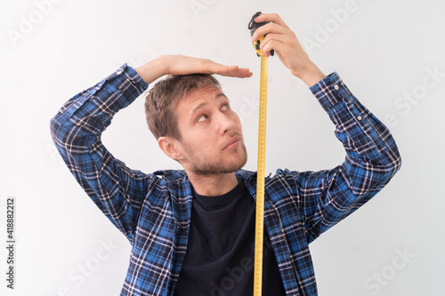 simple adult teenager male person with a roll tape measure the height against the wall