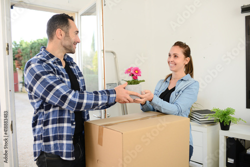 happy young couple moving carboard boxes and furnitures during move into a new home flat apartment photo