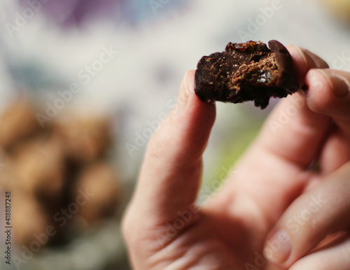 Close-up of a hand holding delicious piece of craft homemade chocolate vegan candy. Edited in instagram style. Tasty gourmet desserts 