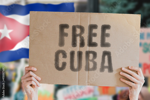 Photography The phrase  Free Cuba  on a banner in men's hand with blurred Cuban flag on the background