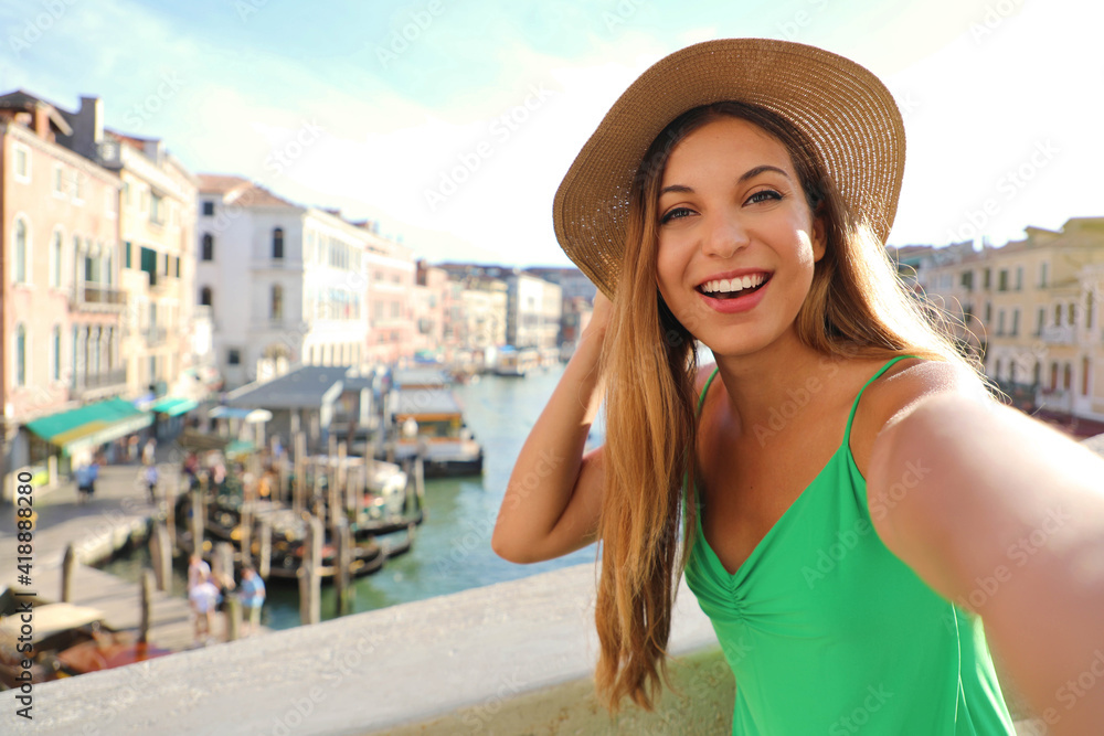 Venice tourist girl on Rialto Bridge taking selfie photo with famous Grand Canal on the background. European tourism attraction in Italy. Young woman on vacation.