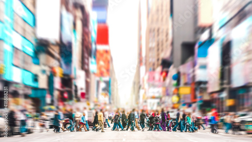 Defocused background of people walking on zebra crossing on 7th avenue in Manhattan - Crowded streets of New York City during rush hour in urban area - Vivid sunset filter with soft sharp focus photo