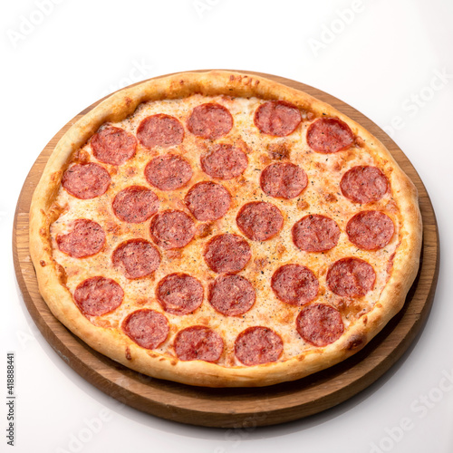 Whole Paperone pizza on white table background. Hot Pizza with sausage on wooden board. Delicious Pizza. Traditional italian food, top view. Nutrition dinner or lunch. Object isolated on white.