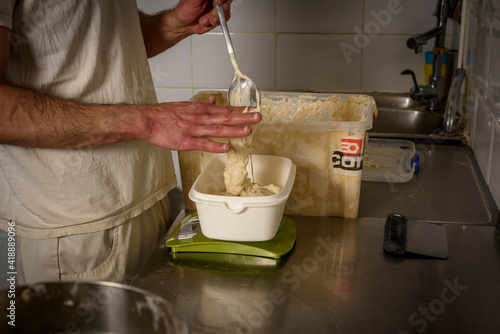 The baker's hands preparing the sourdough to mix before baking the bread.