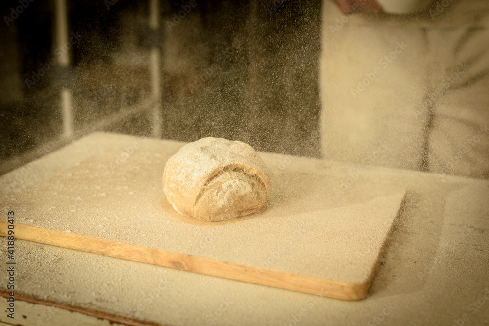 Sprinkle flour over the finished loaf of bread. Sprinkle flour over the finished loaf of bread.