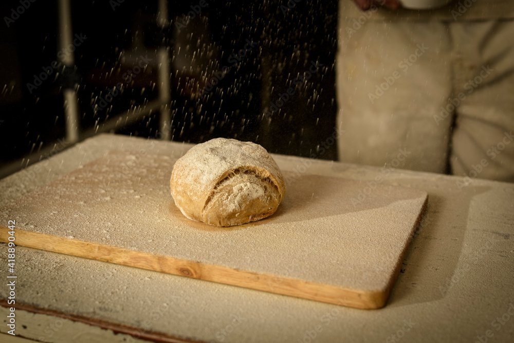 Sprinkle flour over the finished loaf of bread. Sprinkle flour over the finished loaf of bread.