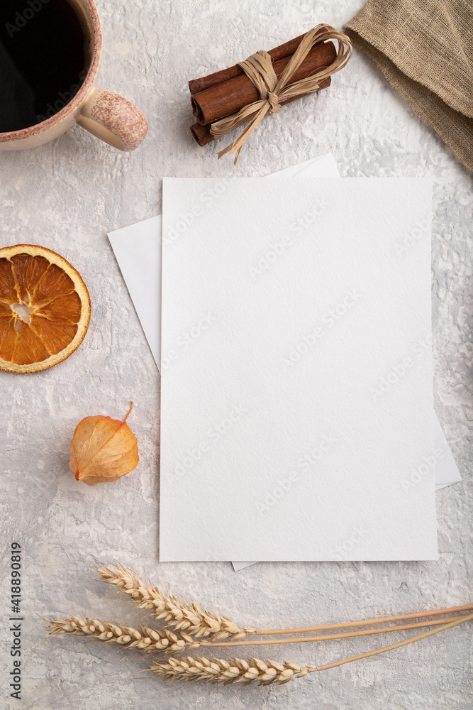 White paper invitation card, mockup with ear of wheat, bun, cup of coffee, linen textile, physalis on gray concrete background. flat lay, copy space. White paper invitation card, mockup with ear of wheat, bun, cup of coffee, linen textile, physalis on gray concrete background. flat lay, copy space.