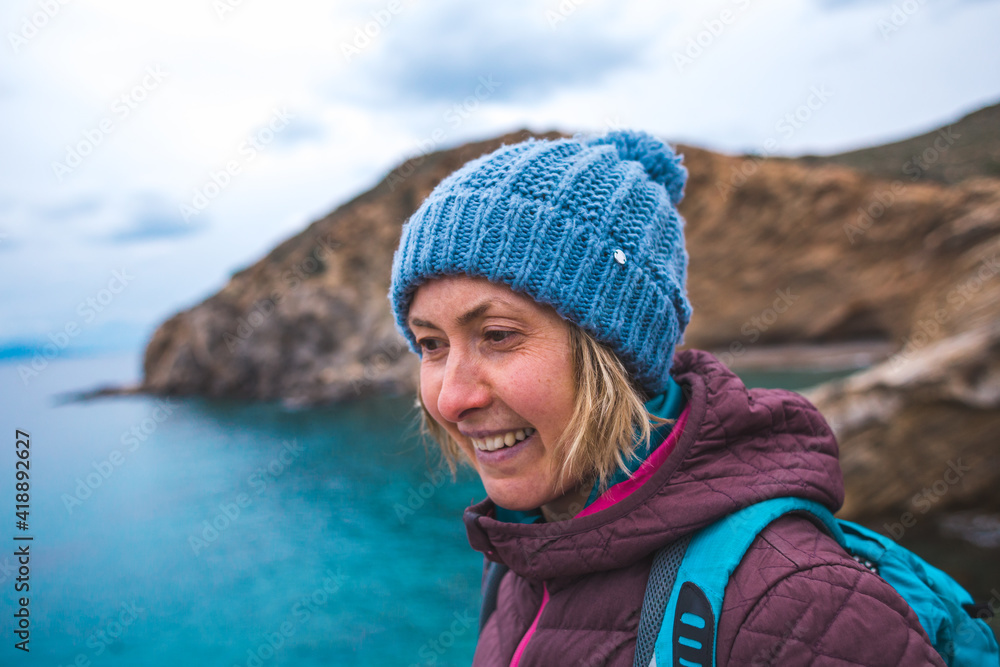 Portrait of a smiling girl in a knitted hat while walking along the sea coast Portrait of a smiling girl in a knitted hat while walking along the sea coast