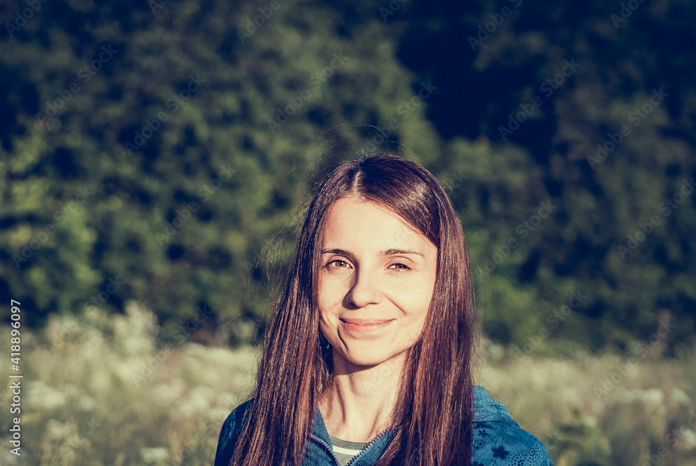 Portrait of female with positive emotions on greenery background. Woman in meadow walking far away at summer time. Girl in casual cloth stroll on summer field. Dreamy tone image Portrait of female with positive emotions on greenery background. Woman in meadow walking far away at summer time. Girl in casual cloth stroll on summer field. Dreamy tone image