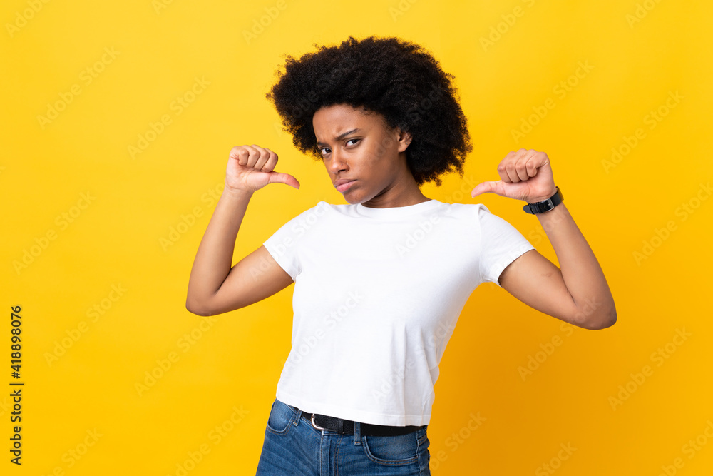 Young African American woman isolated on yellow background proud and self-satisfied Young African American woman isolated on yellow background proud and self-satisfied