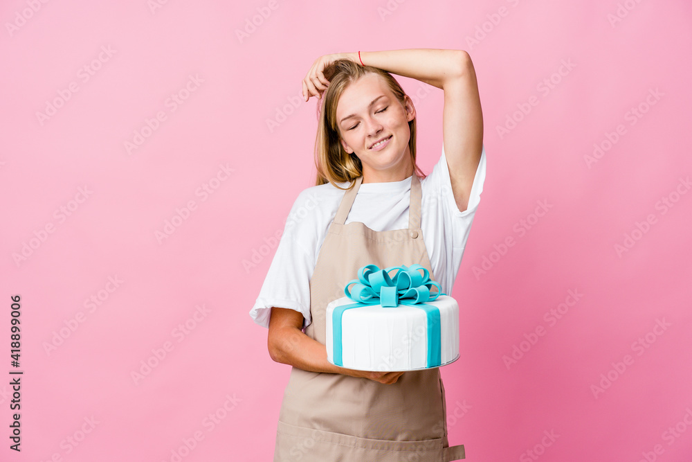 Young russian baker woman holding a delicious cake stretching arms, relaxed position. Young russian baker woman holding a delicious cake stretching arms, relaxed position.
