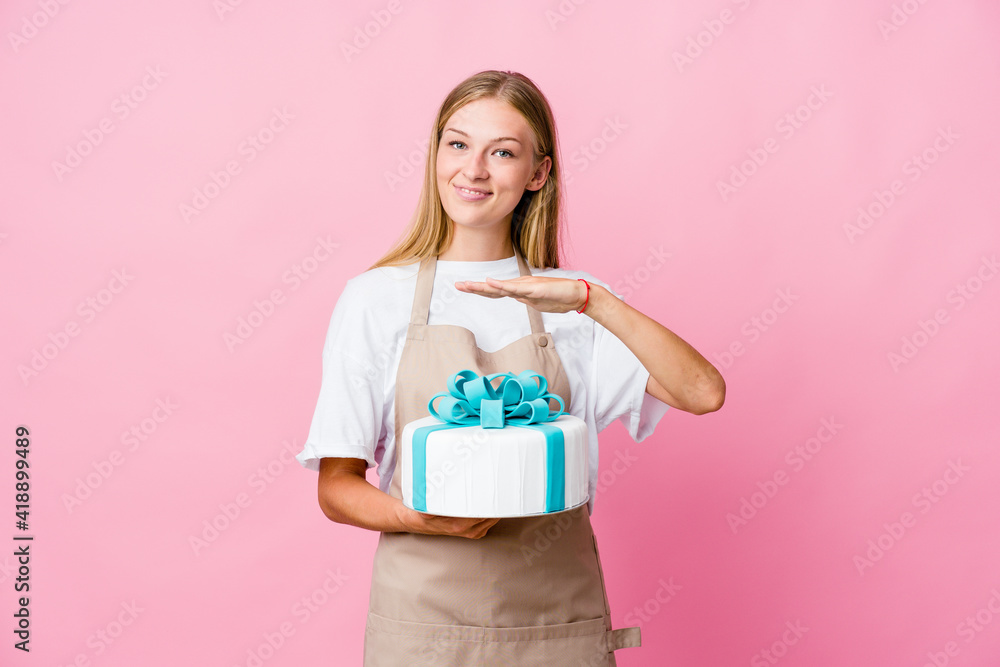 Young russian baker woman holding a delicious cake holding something with both hands, product presentation. Young russian baker woman holding a delicious cake holding something with both hands, product presentation.