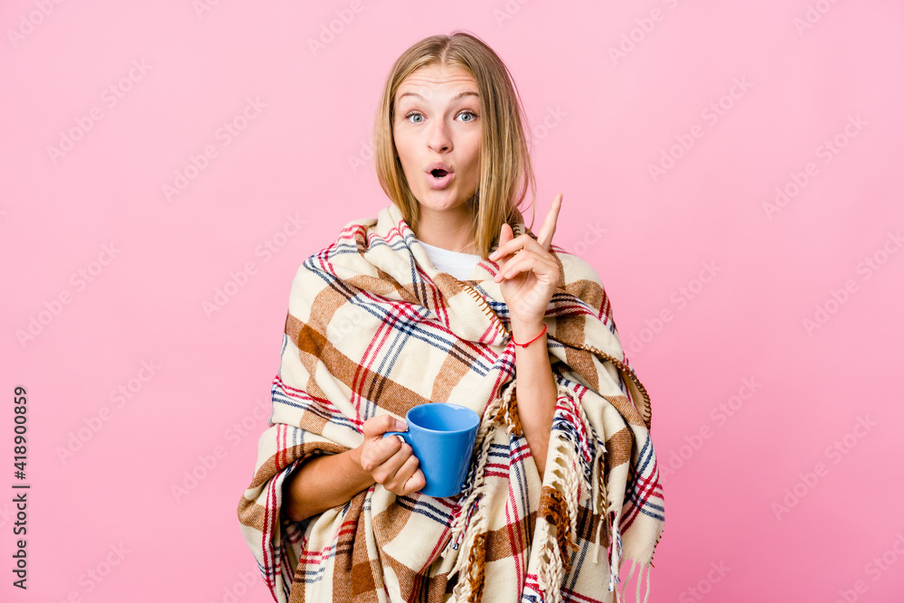 Young russian woman wrapped in a blanket drinking coffee having some great idea, concept of creativity. Young russian woman wrapped in a blanket drinking coffee having some great idea, concept of creativity.