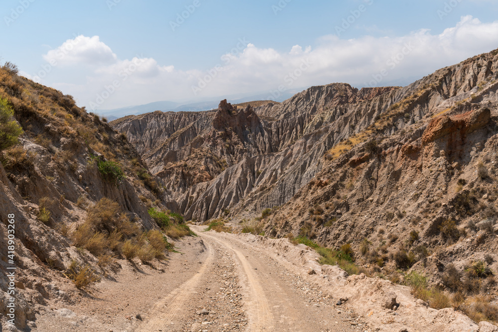 Dirt road between a mountainous and eroded landscape in southern Spain