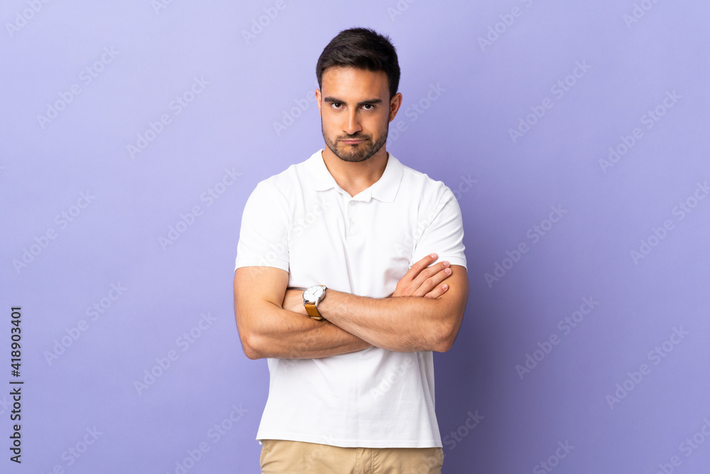 Young handsome man isolated on purple background with unhappy expression Young handsome man isolated on purple background with unhappy expression