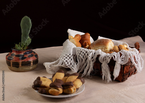 Biscuits and breads or buns in basket decorated with jam or jelly and a cup of coffee
