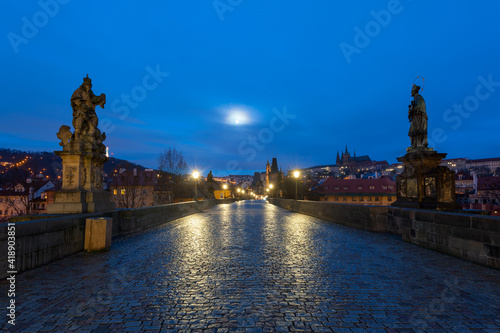 View from the Charles bridge in Prague over the Vlatva river at night with full moon