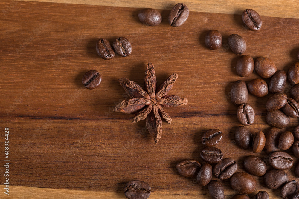 Star anise and roasted coffee beans on a wooden table.