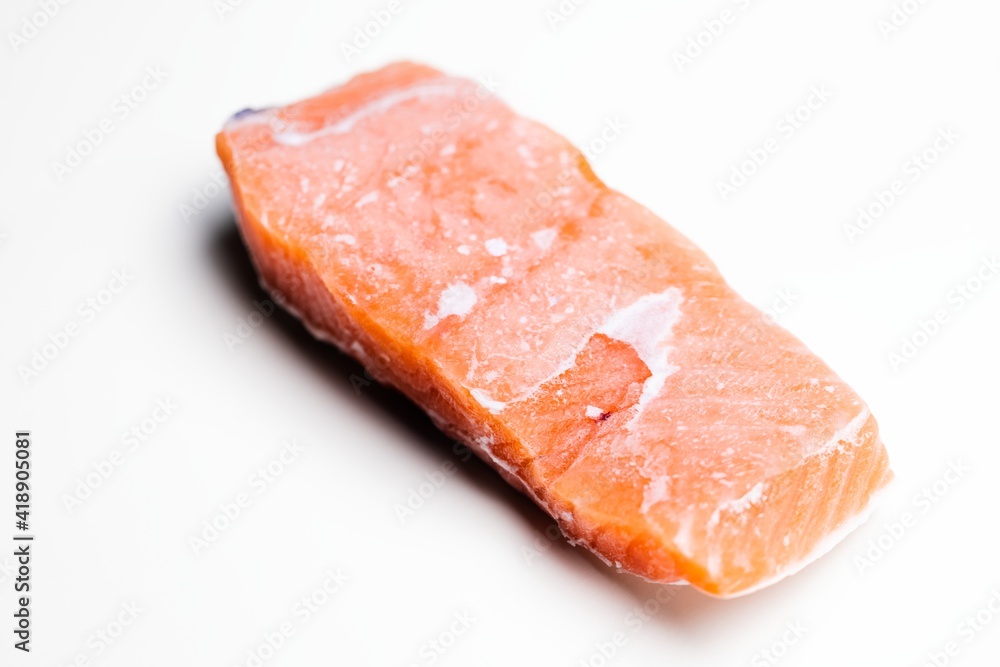 Slice of salmon against isolated white background closeup