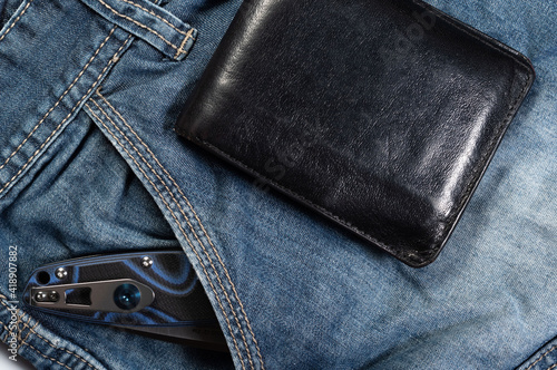 Leather men's wallet and a folding knife in the pocket.