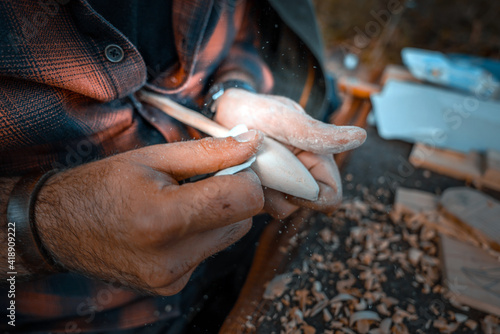 Man carving a wooden spoon. Process of making a wooden spoon