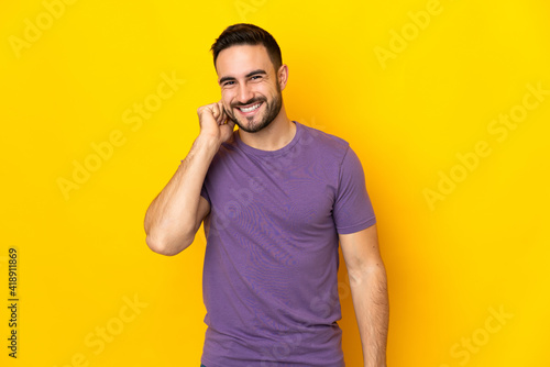 Young caucasian handsome man isolated on yellow background laughing