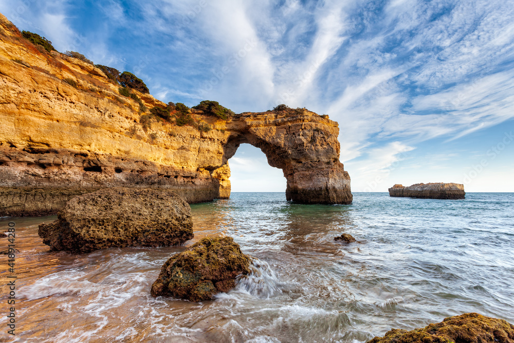 Amazing beach at sunrise. Algarve is located in the south of Portugal and is a vacation destination for many tourists. Your stone arch is an excellent spot for photographers and spearfishing