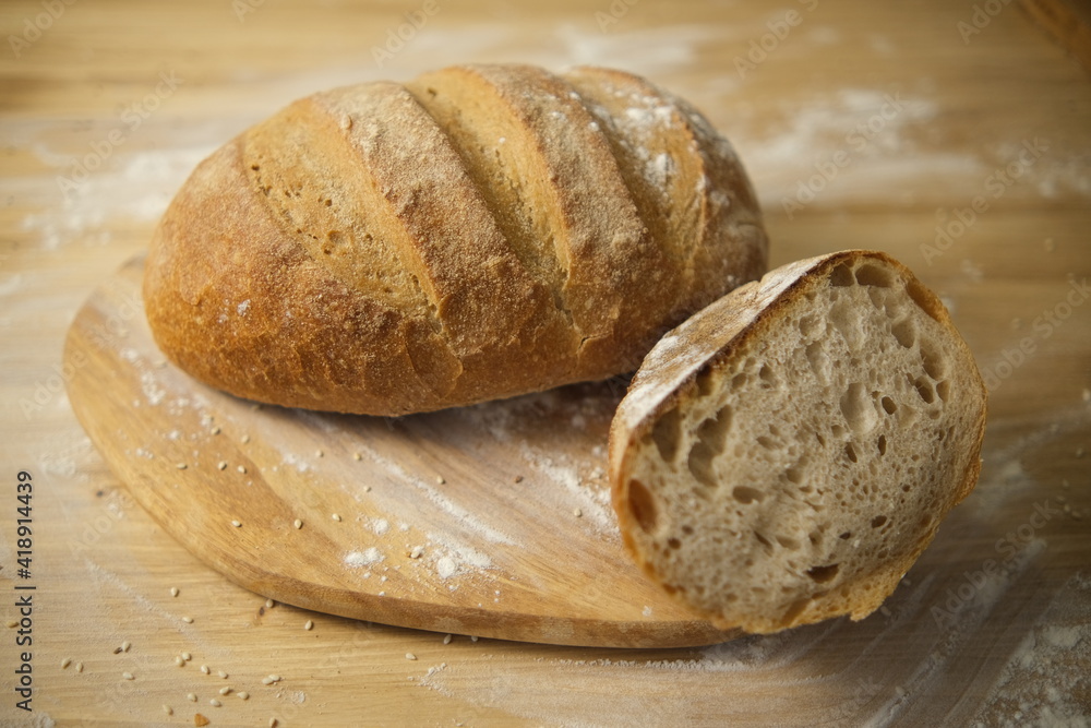 Bread freshly baked on a wooden table. Flour, bakery. The cooking process is captured in 4k resolution. Selective focus. Round loaf Bread freshly baked on a wooden table. Flour, bakery. The cooking process is captured in 4k resolution. Selective focus. Round loaf