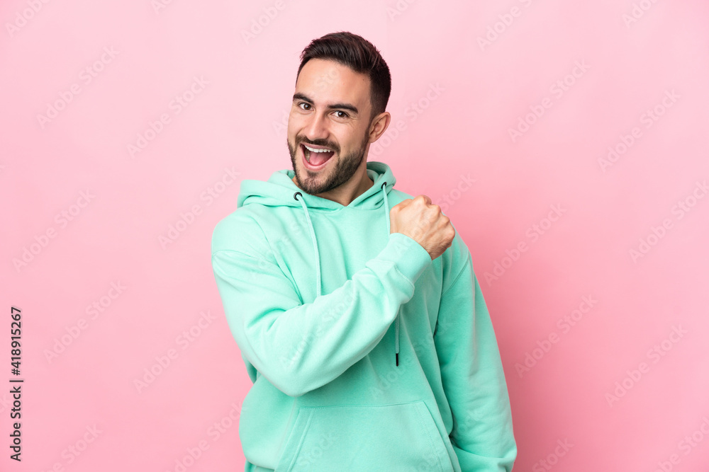 Obraz premium Young caucasian handsome man isolated on pink background celebrating a victory