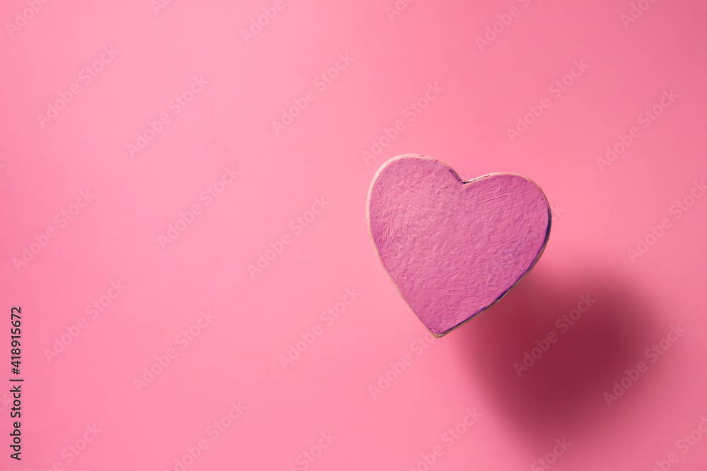 a heart on a pink background and a shadow from it, soft lights