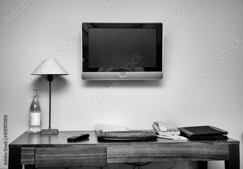 Study room with writing desk keyboard phone lamp and lcd tv set