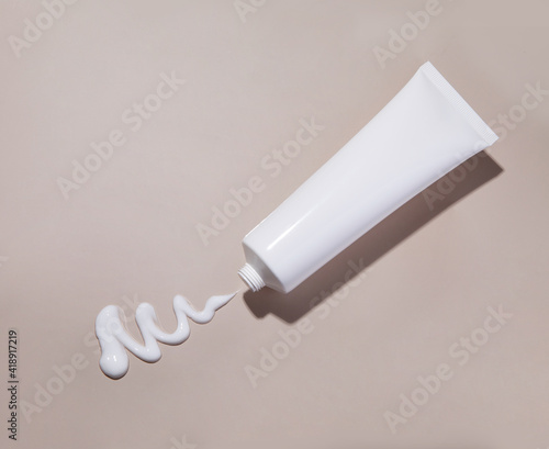 Photo Cosmetic cream tube and stroke on beige background