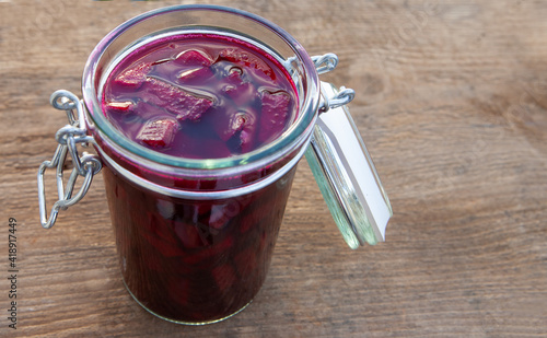 Jar of beetroot leaven on a board.