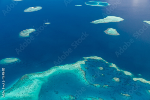 Islands aerial view. Aerial photo of beautiful Maldives paradise tropical beach. Coral reef, blue turquoise lagoon water. Luxury travel