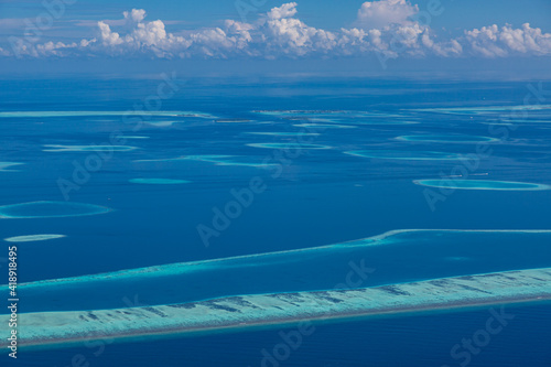 Islands aerial view. Aerial photo of beautiful Maldives paradise tropical beach. Coral reef  blue turquoise lagoon water. Luxury travel