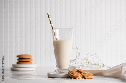 Glass of milk with homemade cookies on a white background. Breakfast and healthy food concept. white on white photo
